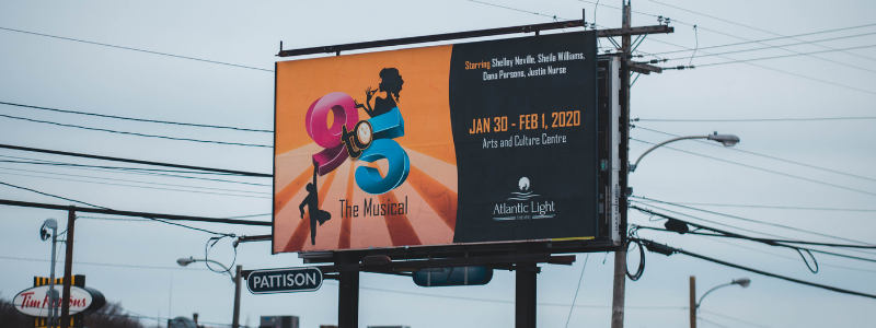 billboard of musical overlooking city highway